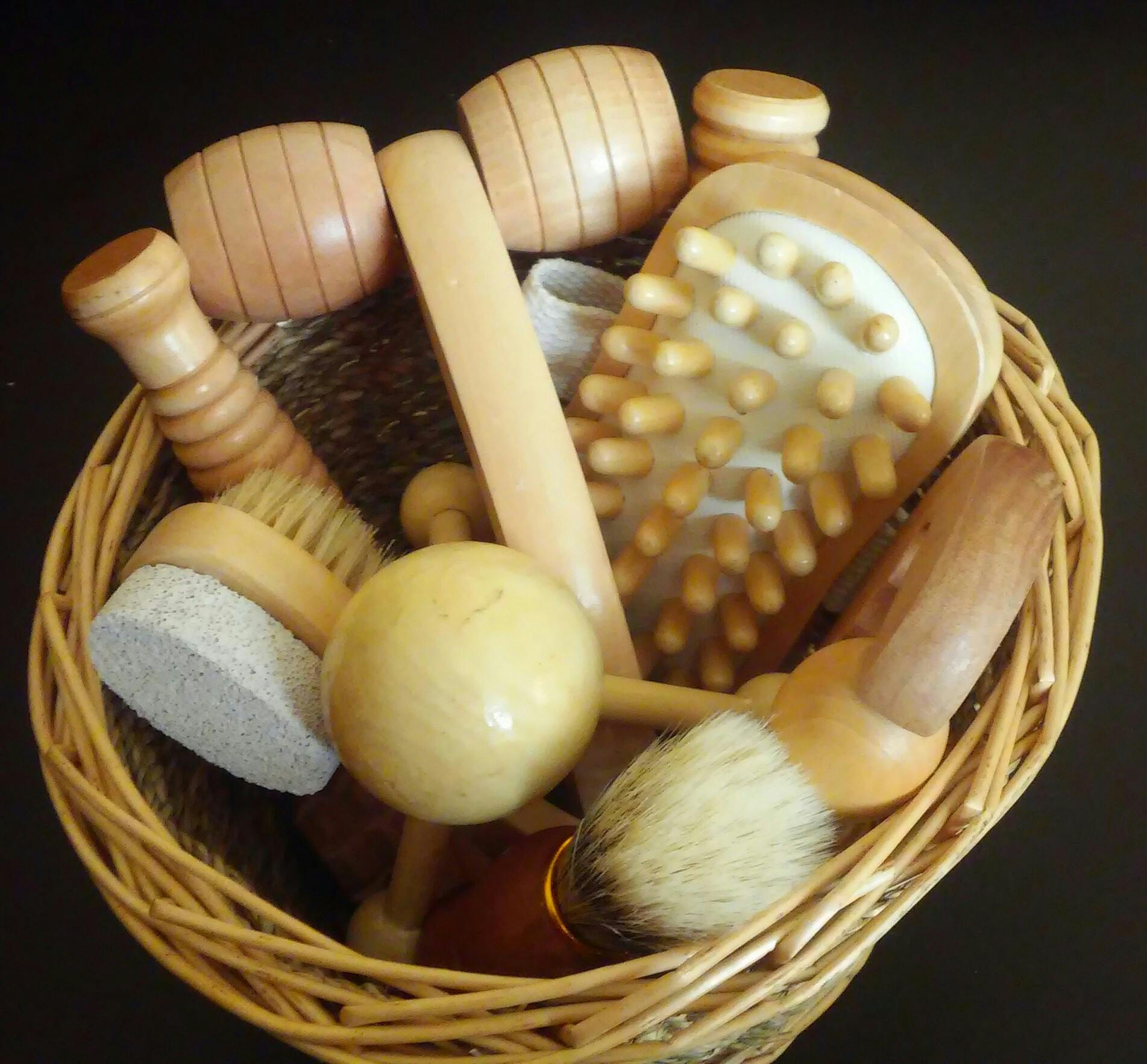 Top view of various wooden massage tools neatly arranged in a woven basket.